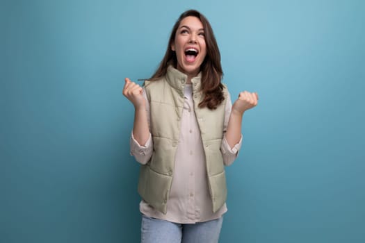 joyful cute young brunette woman dreamily looks away on the background with copy space.