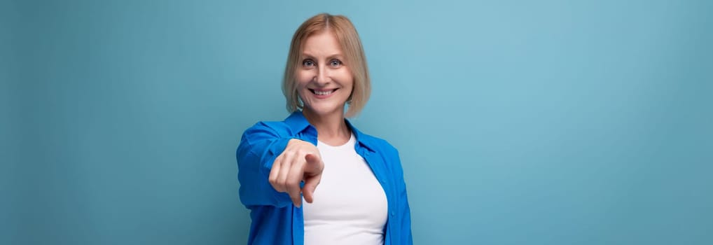 panoramic photo of confident middle aged woman in blue stylish shirt on studio background.