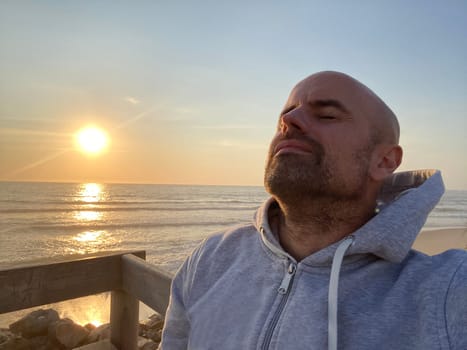 Profile of a of man breathing deep fresh air at sunset.