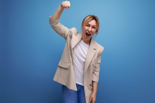 positive blonde young woman in casual style on studio background.