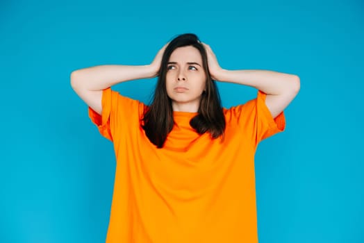 Unsatisfied Girl Touching Head, Frustration Concept - Empty Space, Disgruntled Expression, Isolated Blue Background.