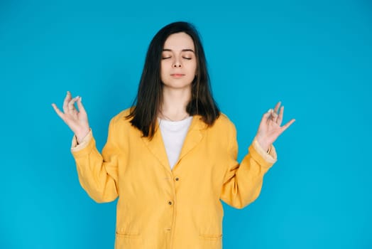 Serene Young Woman Practicing Yoga Meditation - Relaxation, Balance, Mindfulness, Serene Relaxation, Inner Peace, Mindfulness, Isolated on Blue Background.