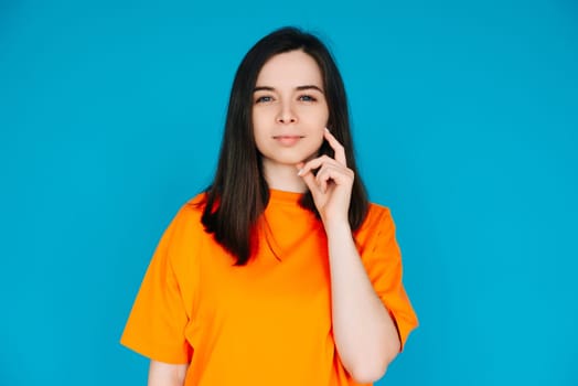 Thoughtful Woman Touching Chin, Contemplating, Copy Space, Isolated on Blue Background. Portrait of a Beautiful Woman Touching Her Chin, Contemplating.