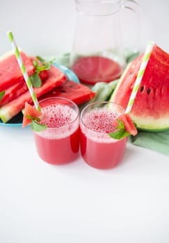 Juicy fresh watermelon juice in a glass along with a green tube, delicious and healthy summer food