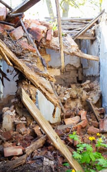 Old abandoned one-story house in disrepair. Collapsed walls