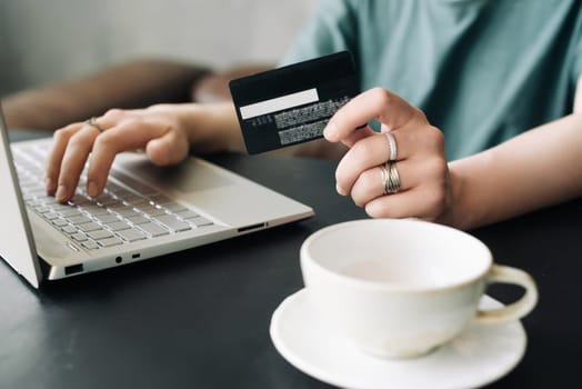 E-Commerce at Home: Woman Making Online Purchases with Credit Card and Laptop - Internet Banking, Digital Consumerism, and Remote Work Concept.