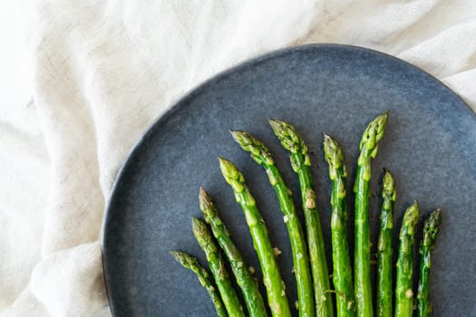Close-up on a large plate - asparagus with salt and garlic. Delicious and healthy food, served in a restaurant, beautiful layout
