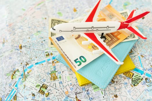 Paris city map composition with euro banknotes, dollars, passports and a toy plane. Travel and vacation concept