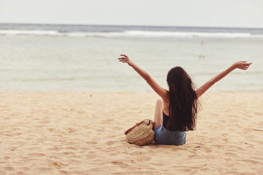 fashion woman carefree back happy sea pretty adult smile freedom vacation relax caucasian beach view sand girl coast travel sitting nature attractive
