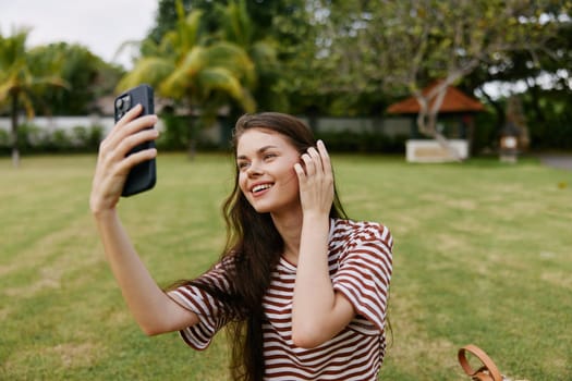 human woman nature park person cell student spring smiling grass happy mobile young smile girl palm seasonal blogger working lifestyle tree phone