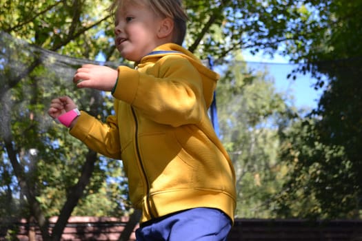 A boy on a trampoline in the garden. . High quality photo