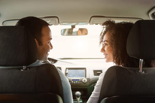 Couple On Road Trip. Middle Eastern Spouses Driving Enjoying Ride Sitting In Front Seat In Vehicle. Back View Shot Of Happy Auto Owners Traveling By Auto Together. Dealership Offer Concept