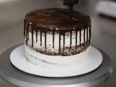 pastry chef preparing a chocolate frosted dripped icing cup cake with sweet fruit topping and golden brush strokes