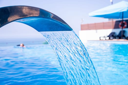 Empty Swimming pool with waterfall jet and jacuzzi in action