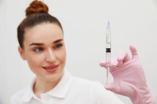 Female doctor showing syringe with liquid for skin tightening