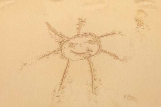 Kid drawn sun in wet sand on the beach.