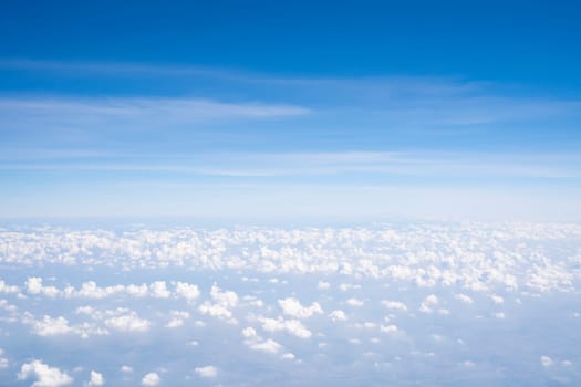 Aerial view of Fluffy clouds Top view from airplane window, Nature background.