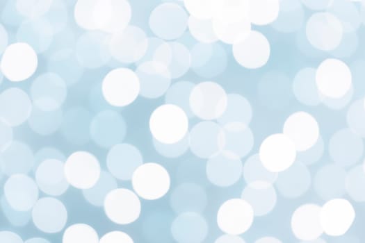 Light blue glitter festive abstract background with bokeh lights.