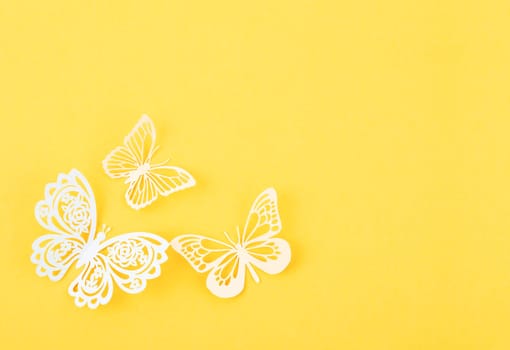 Paper butterfly carve on a yellow background with empty space.