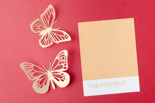 Blank reminder note and carve of paper butterfly on red background, space for text.