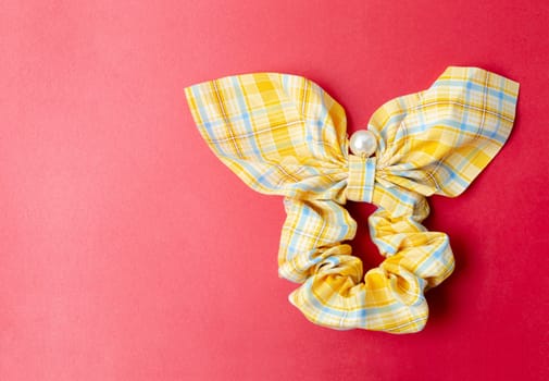 Beautiful yellow hair ribbon bow tie on red background.