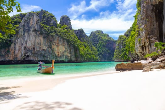 Thai traditional wooden longtail boat and beautiful beach in Phuket province, Thailand.