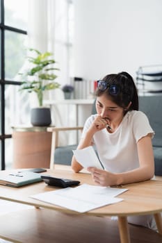 Asian accounting professional calculating household bills, reviewing and analyzing household bills, and filing tax returns.