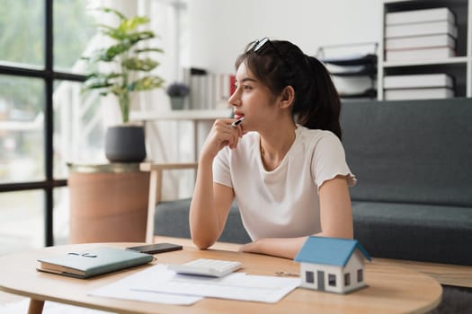 Asian accounting professional calculating household bills, reviewing and analyzing household bills, and filing tax returns.