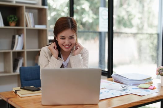 Asian Business person makes analysis and research financial report at office, analyzes profits. Accountant checks status of financial.