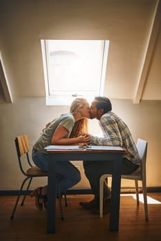 Holding hands, love kiss and couple at restaurant, having fun or bonding at table. Valentines day, romance diversity or affection, kissing or care of man and woman enjoying romantic date time at cafe.