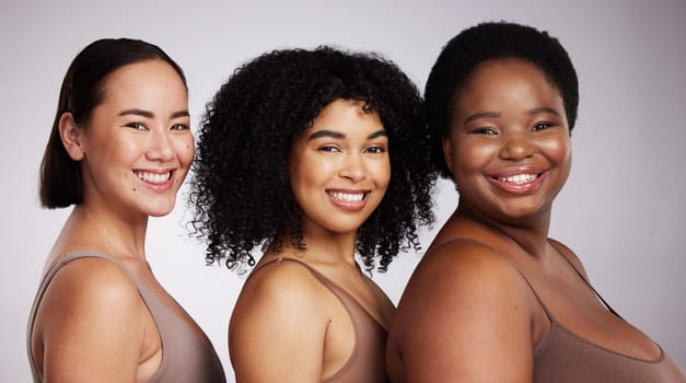 Women, diversity studio portrait and smile for aesthetic, beauty or race equality with plus size solidarity. Model, asian and black woman with cosmetic, makeup and wellness with support for inclusion.