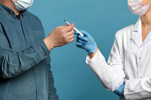 Young doctor measuring temperature of a patient with thermometer