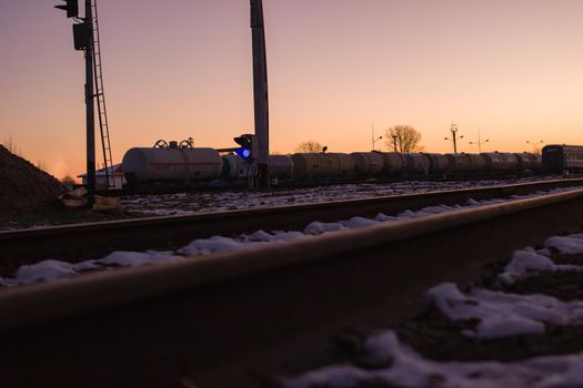 Railroad rails in the snow in the dark at dawn