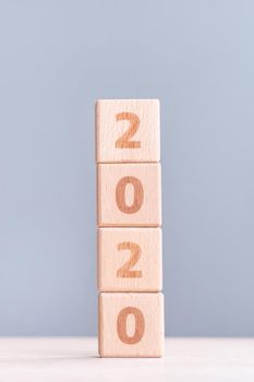 Abstract 2020, 2019 New year target plan design concept - wood blocks cubes on wooden table and pastel blue background, close up, blank copy space.