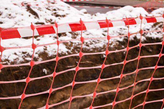 Red ribbon on construction work fence close up