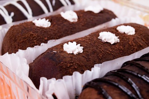 Chocolate cakes with cream close up on wooden table