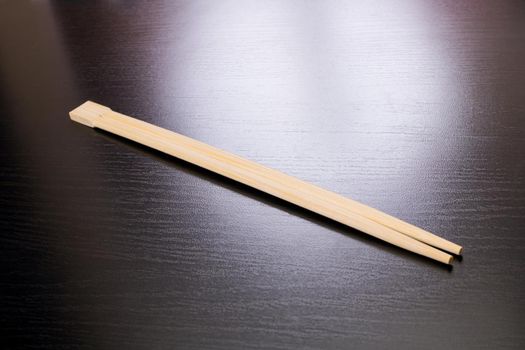 Wooden chopsticks on a black table close up