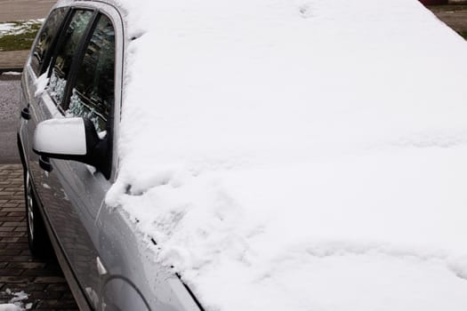 A lot of snow on the hood of the car