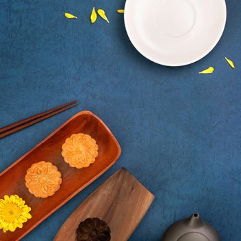 Minimal simplicity layout moon cakes on blue background for Mid-Autumn Festival, creative food design concept, top view, flat lay, copy space.