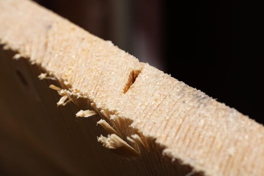 Sawing a wood board with a saw close up