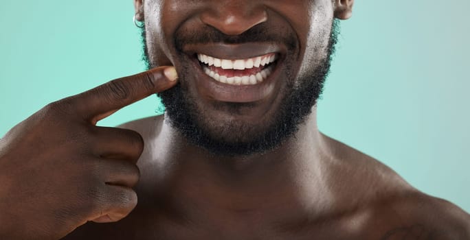 Mouth, dental and teeth with a black man in studio on a blue background for oral hygiene at the dentist. Healthcare, insurance and whitening with a male touching his face or cheek for health.