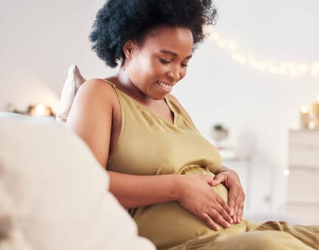 Pregnant stomach, heart hand sign and happy black woman feeling mother hope and love. Mom care, sofa and living room lounge with a person holding abdomen happy about pregnancy and baby in a house.