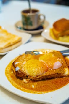 Eggs, toast with Kaya and Butter and coffee, traditional breakfast meal in Kuala Lumpur