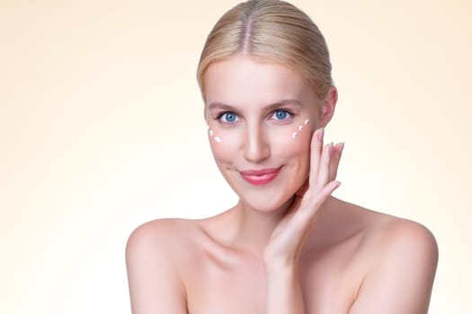 Personable beautiful perfect clean skin soft makeup woman finger applying moisturizer cream on her face under contour eye for anti aging wrinkle. Facial skin rejuvenation in isolated background.