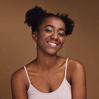 Black woman, smile and student portrait of a gen z person with makeup and jewelry in a studio. Isolated, brown background and happiness of a young female with skincare glow, cosmetics and face.