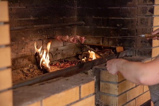 Marinated shashlik preparing on a barbecue grill over charcoal. Shashlik or Shish kebab popular in Eastern Europe.
