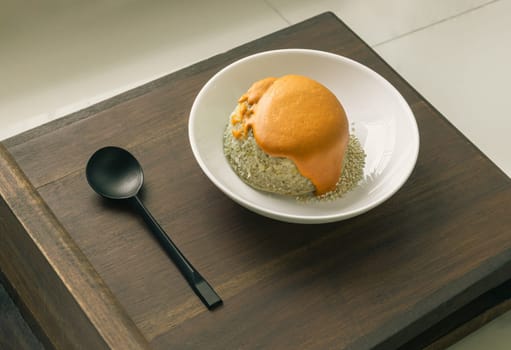 Delicious Homemade Oat Lava Cake with White Sesame in White Ceramic Plate erved with Spoon on the Wooden plank. Delicious Bakery Concept, Space for text, Selective Focus.