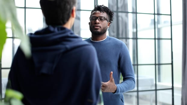 Business people talking near glass wall in office