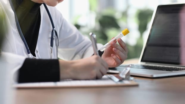 Female professional doctor hand making notes in medical journal.