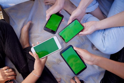 Top view, hands or people with green screen phones for social media app, internet esports game or music sharing software. Men, women or friends with mock up technology space on bonding beach picnic.